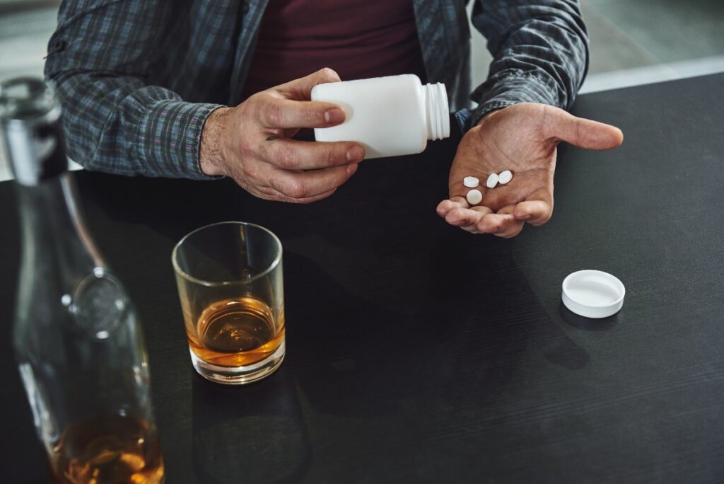 man struggling with alcohol and prescription pill addiction