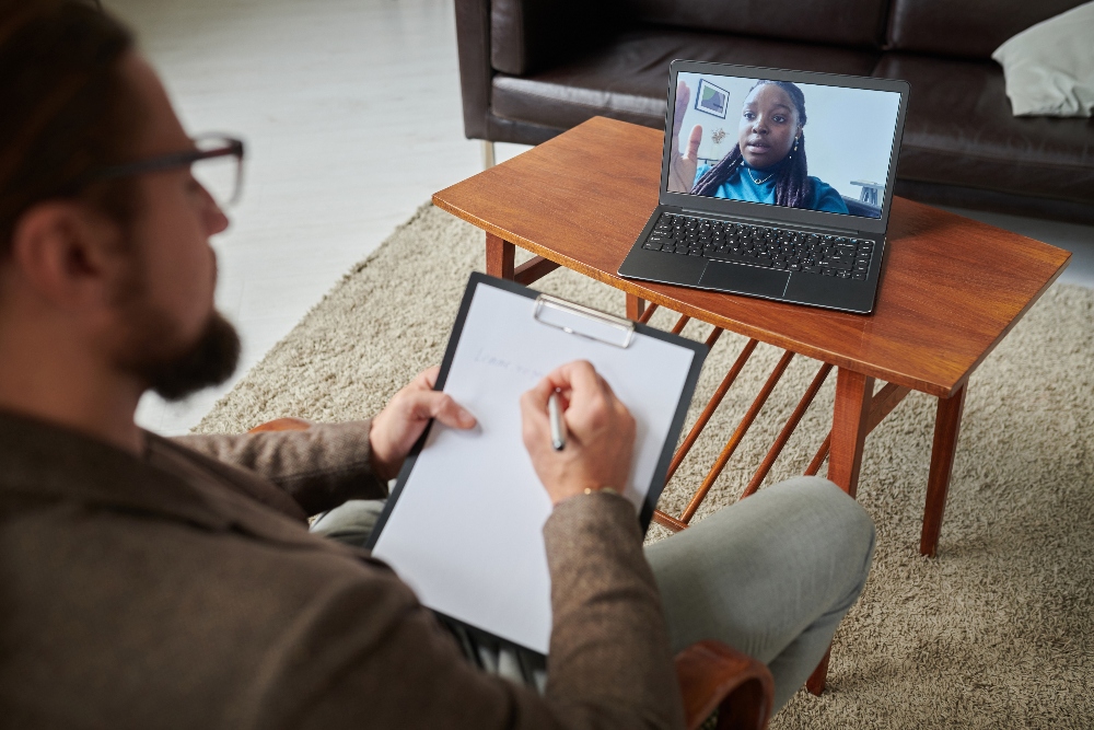 man meeting with therapist online for virtual iop for addiction treatment