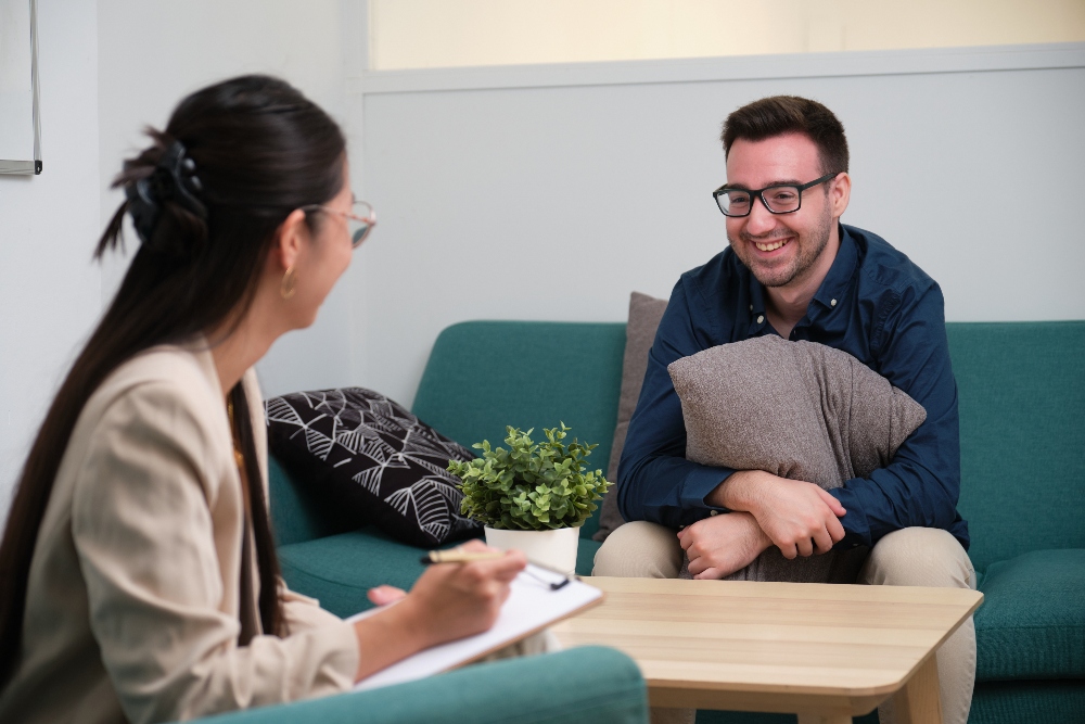 man meeting with therapist for adhd treatment los angeles holding a pillow on his lap