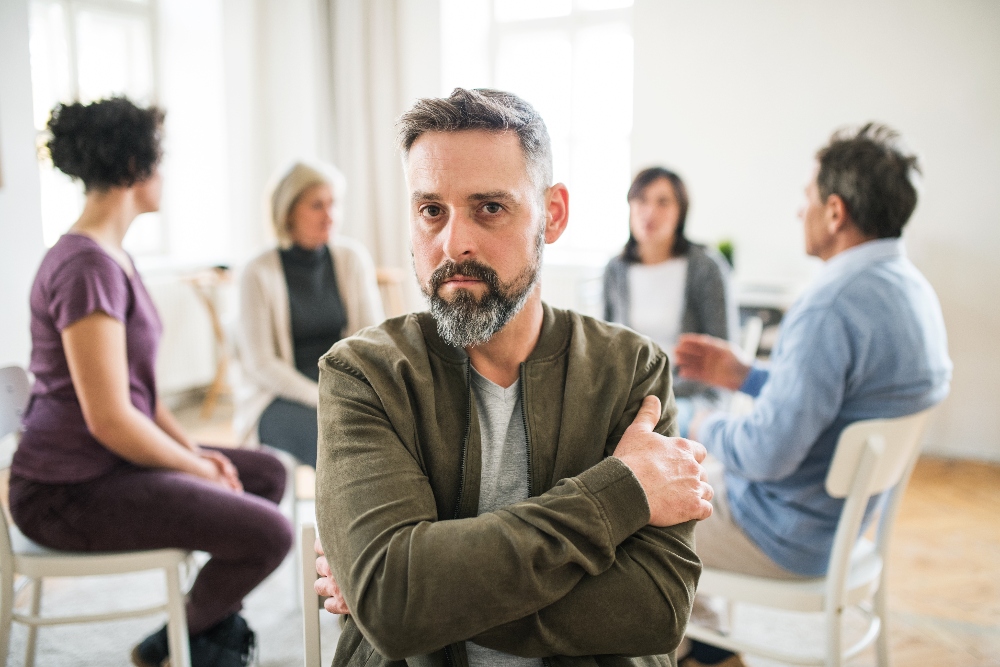 man sitting in group therapy