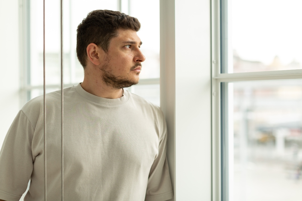 man staring out window
